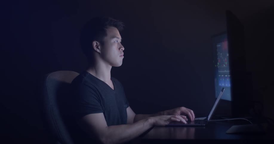 Man at desk typing on laptop