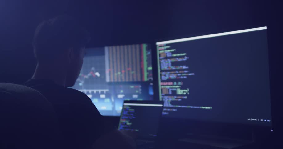 A man sitting in a dark office on a computer