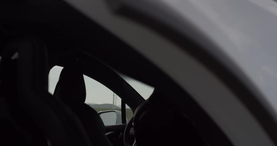 Man Driving Electric Car Through Wind Farm