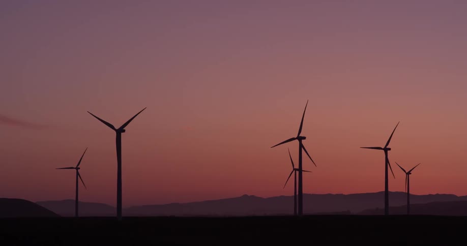 Windmills spinning during sunset