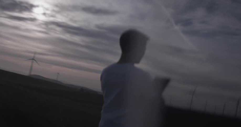 A man that is using a drone controller at sunset