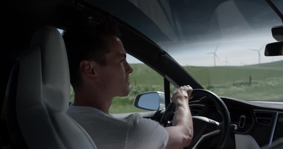 A man driving a car down a dirt road
