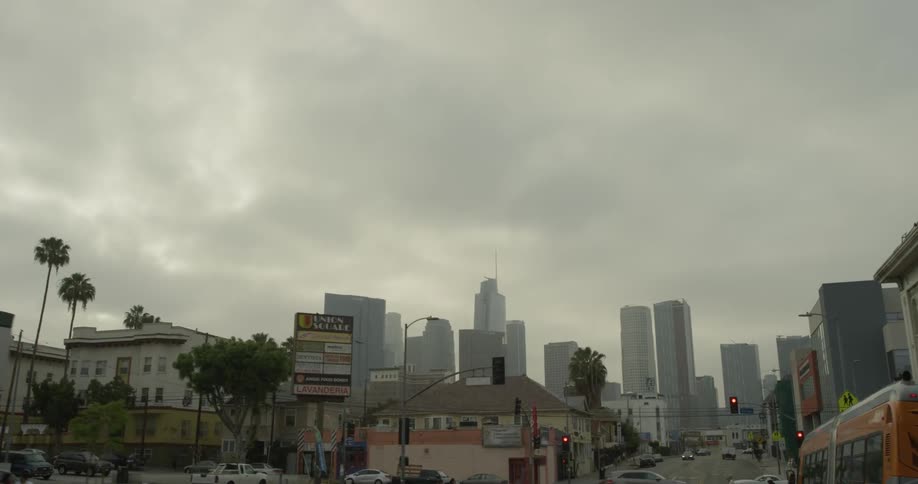 A car driving through a city that is cloudy