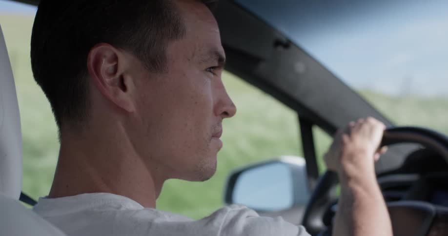 Man Driving Electric Car Through Wind Farm