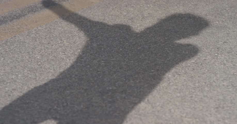 A shadow of a man is on the sidewalk