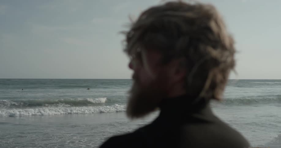 Man stares out at ocean while on the beach