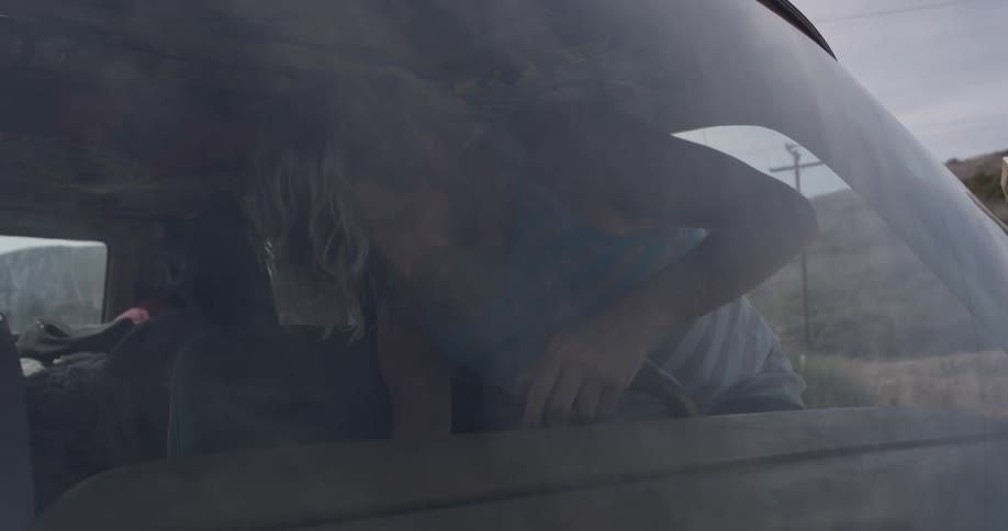 A man gets into a vehicle and closes the drivers side door behind him