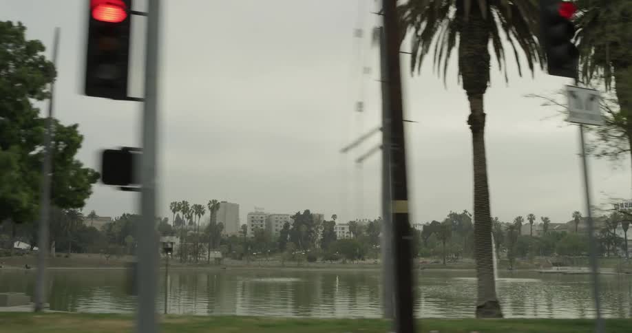 A city park that has a lake with a fountain in it