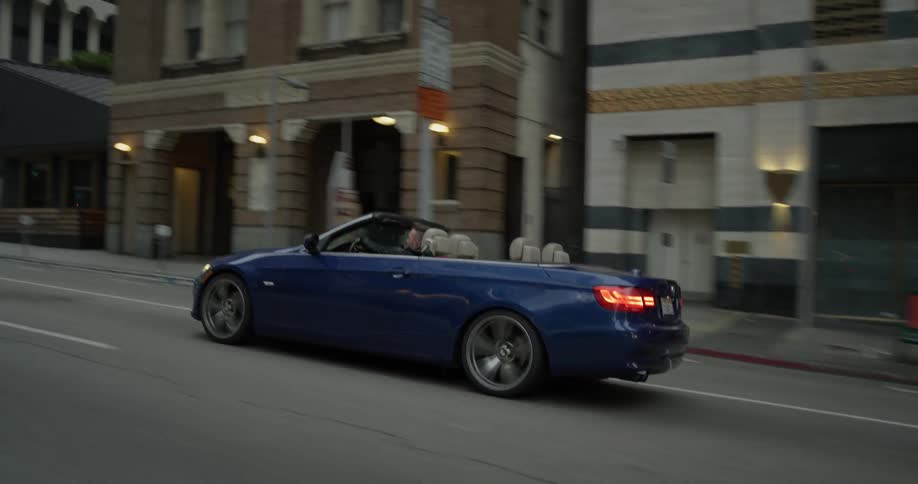 A convertible is driven down the street