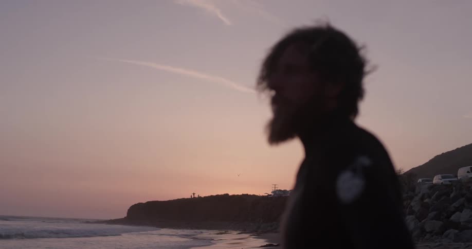 Man stands on the beach at sunset