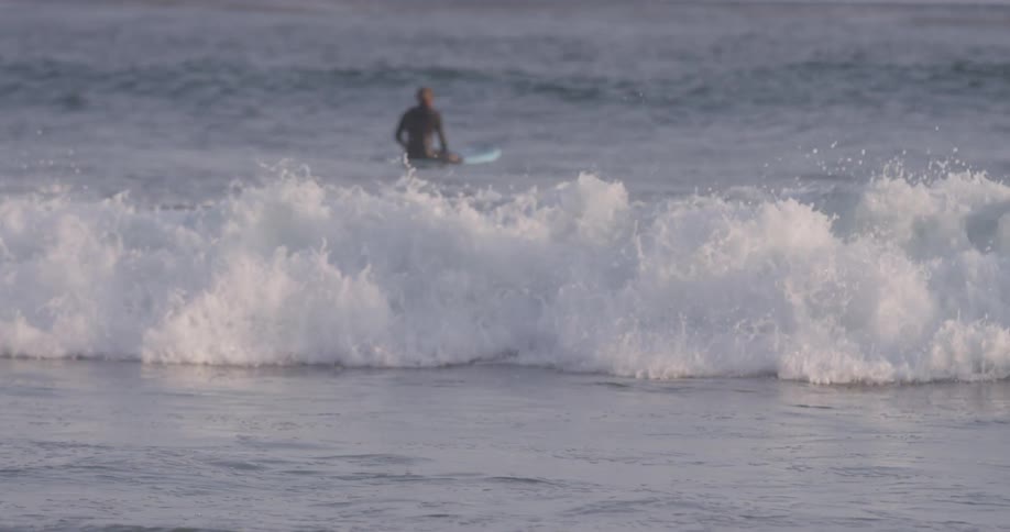 Man rides on a surfboard in the ocean