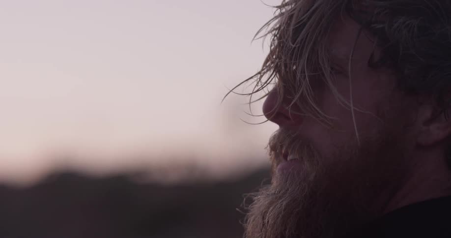 Man looks out at nature at sunset