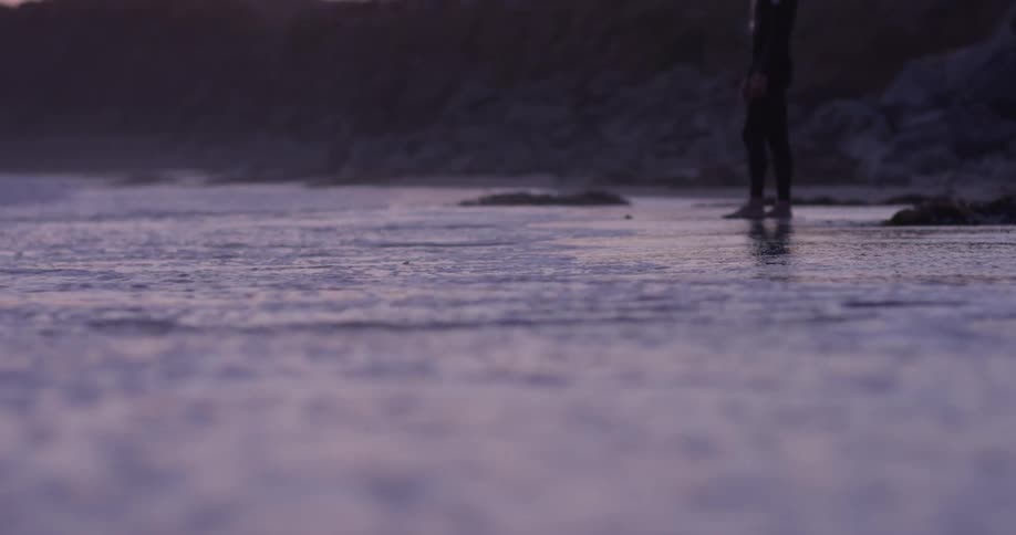 A man looking at the waves along the beach