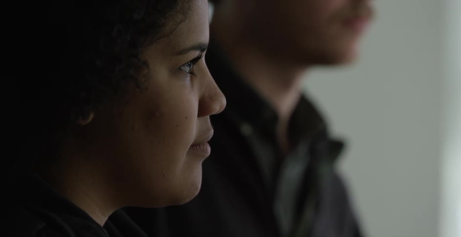 A man and a woman are standing indoors together