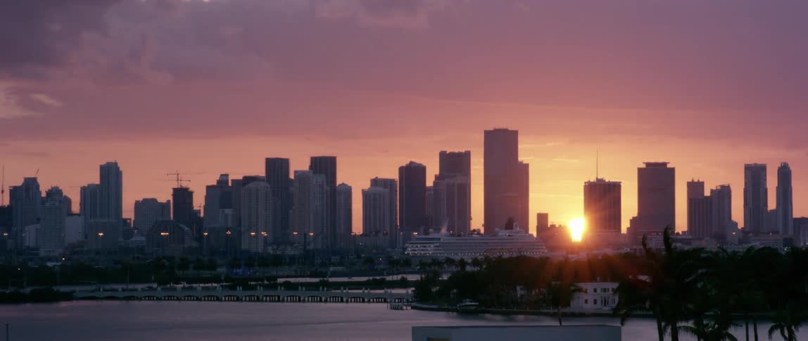 A city is shown at sunset