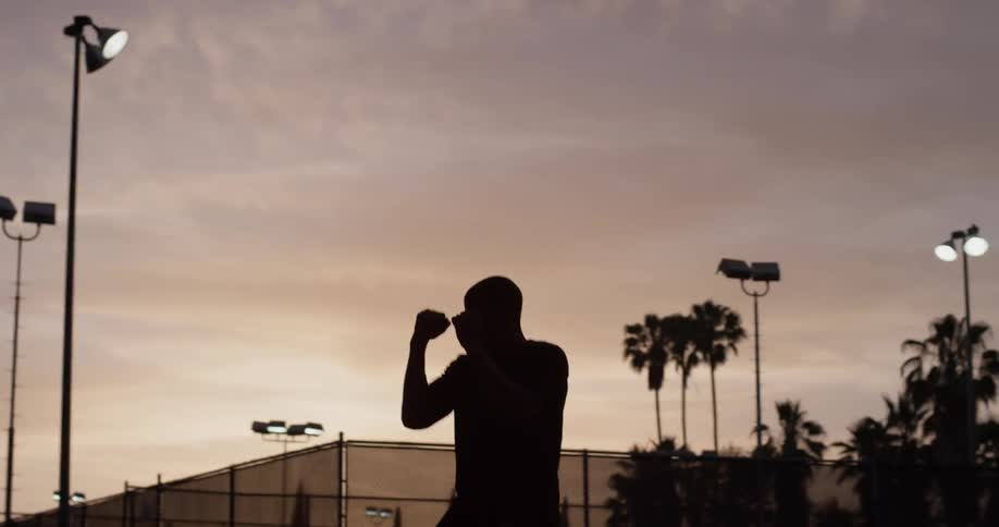 A man shadow boxes outside