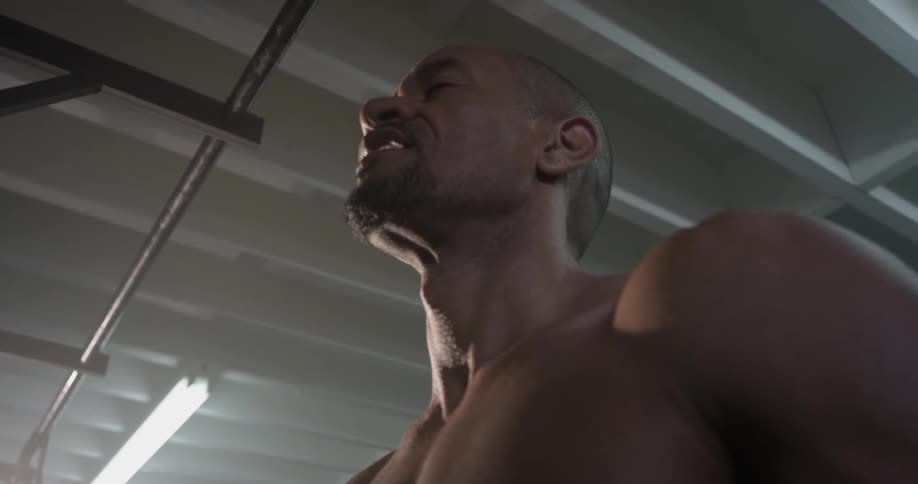 A man doing pull ups in a gym