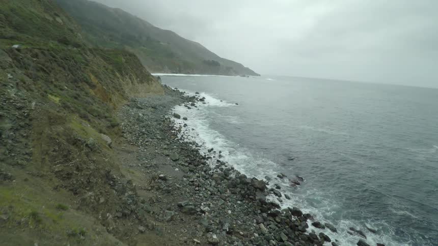 The sea meeting the shore line, with hills behind the shore