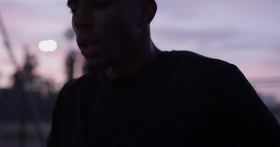 Man breathes deeply and hits head while outdoors at dusk