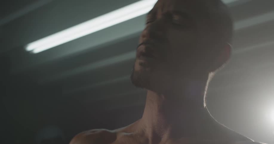 Man stands in a well lit room stretching his neck