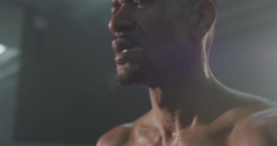 A man shaking his head and stretching in a gym