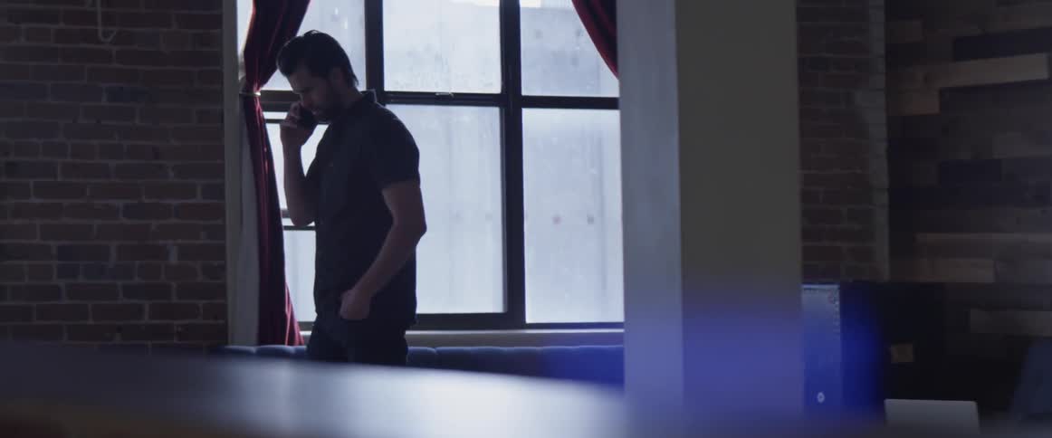 Man Working On Laptop And On The Phone
