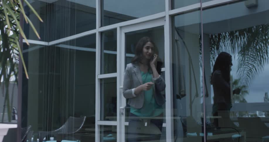 A woman walking in through a glass door
