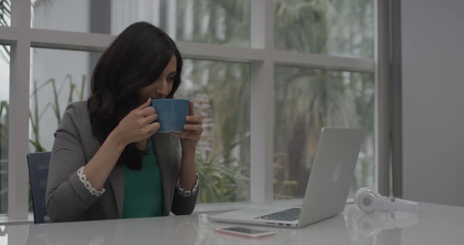 A woman typing on a laptop in an office