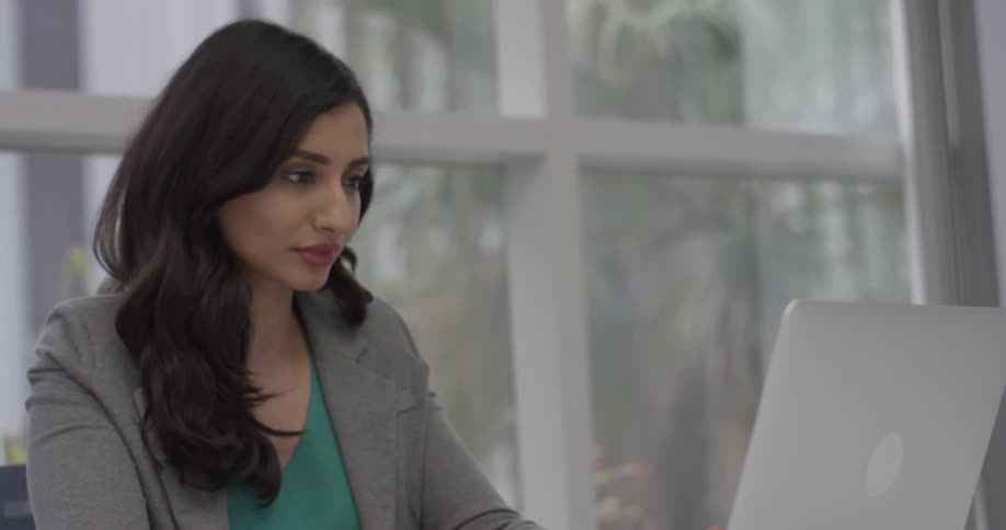 A woman that is entering a credit card number on a laptop