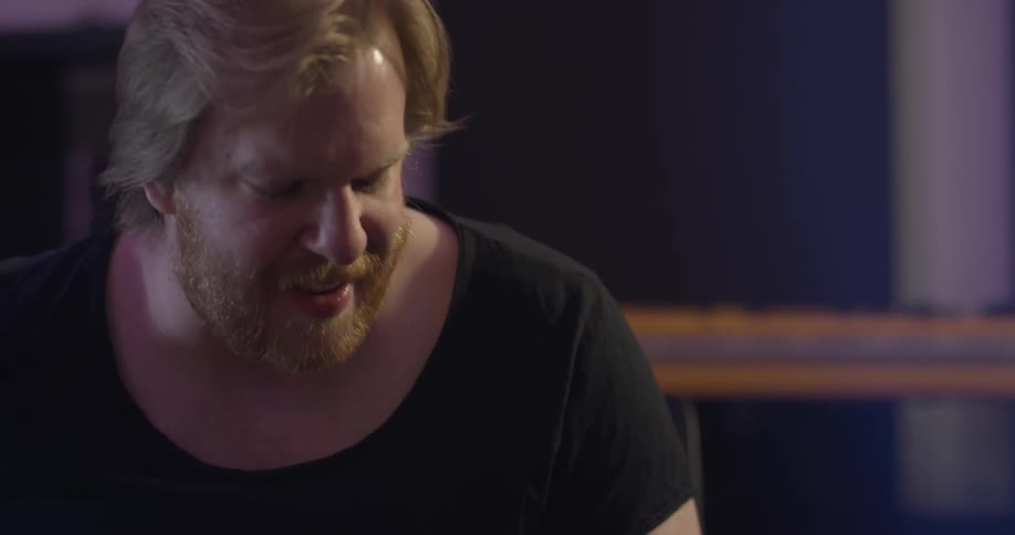 A man playing a guitar in a studio