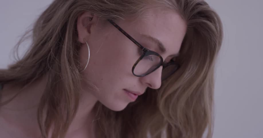 Woman with glasses looks down
