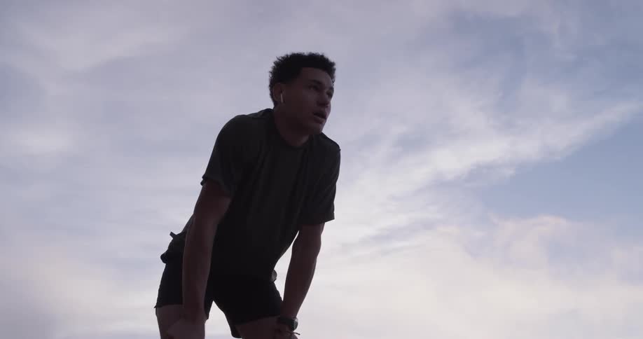 A man stops running to take a breath then continues running