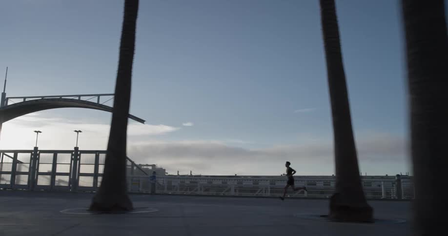 A man running around a park with trees
