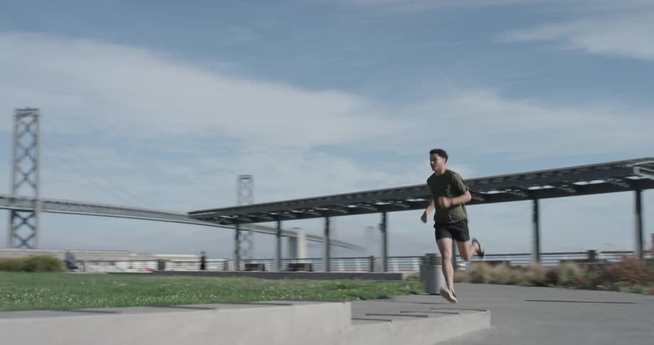 A man running around a park on a sidewalk