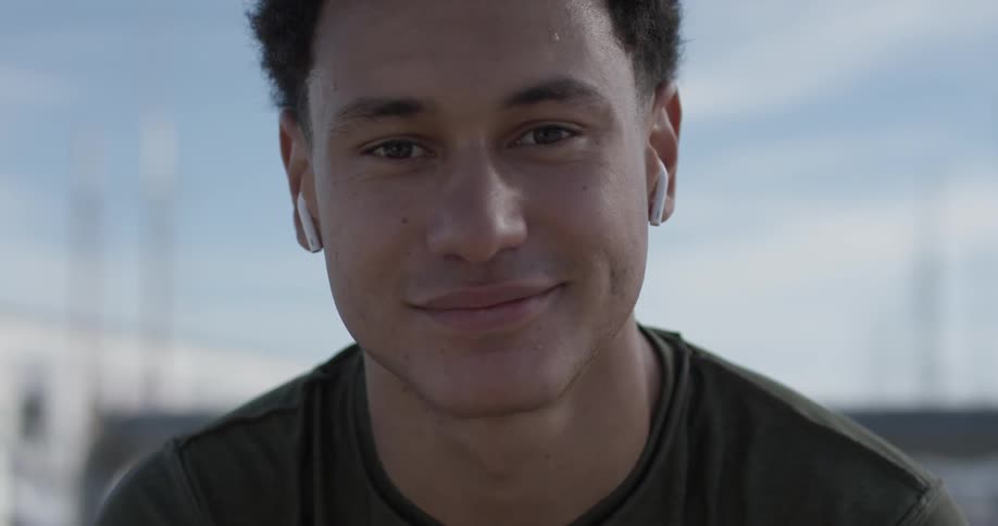 A man smiling while wearing headphones