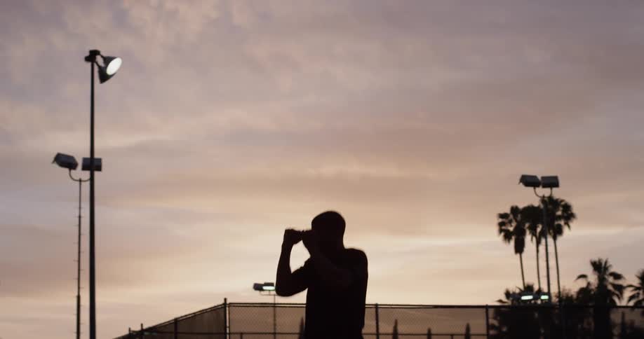 A man shadow boxes outside