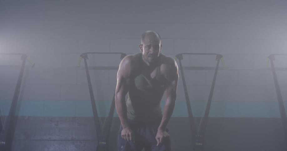 A muscular man has his hands on his hips