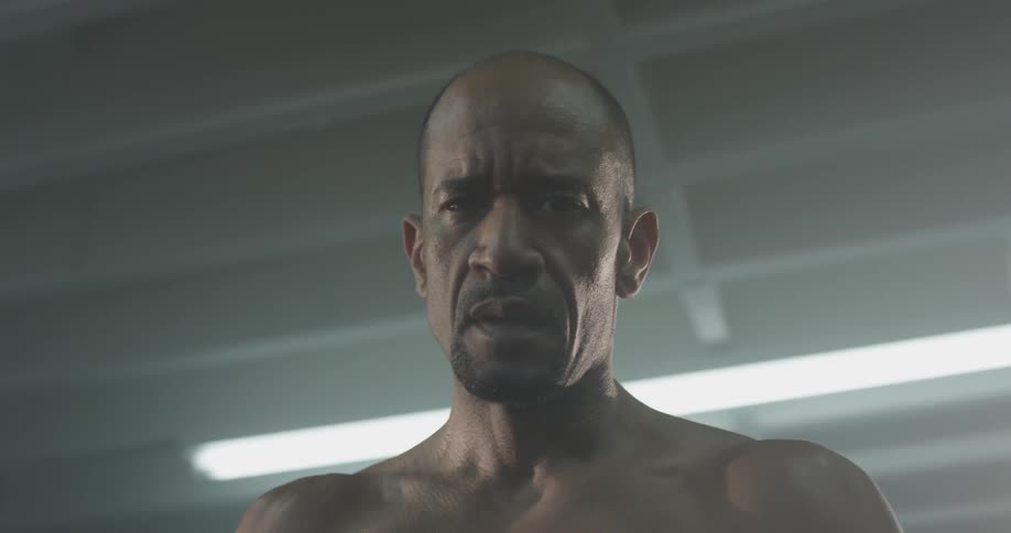 Bodybuilder breathes heavily while staring into the camera