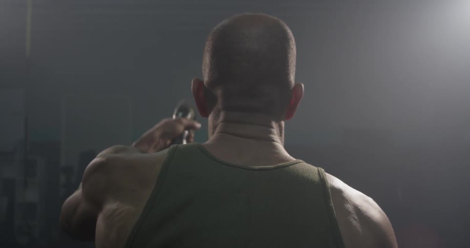 A muscular man whips two ropes up and down with one in each hand