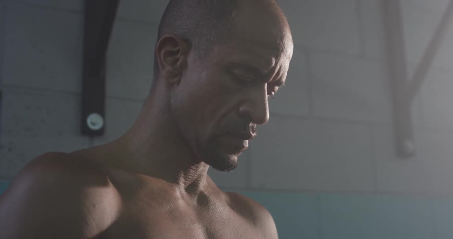 A man standing in a gym looking down