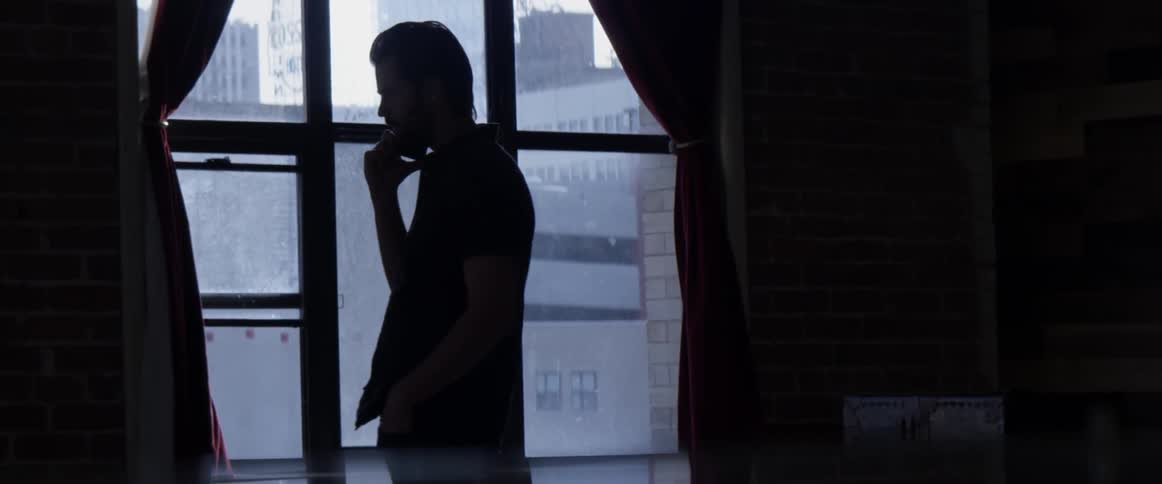 A man walking around a room talking on a cellphone