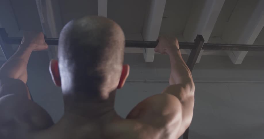 A man doing pull ups at a gym