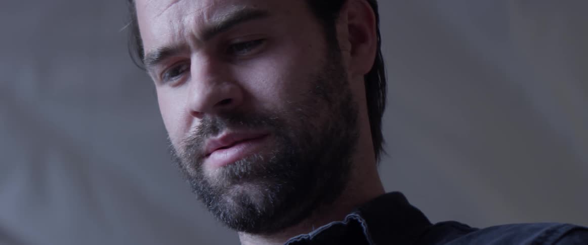 A man looking down at something on the ground