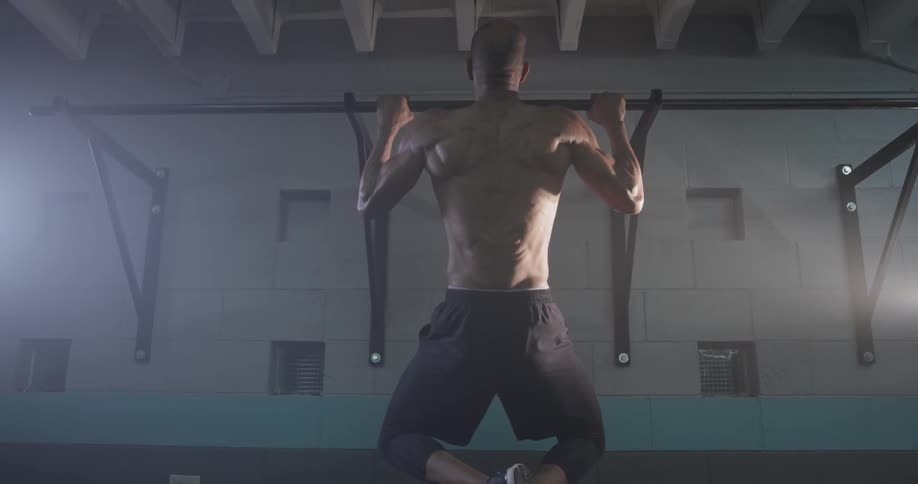 A man doing pull ups in a gym