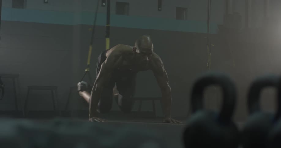 A man doing exercises with straps on the wall