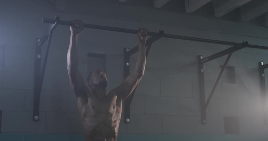 A man doing pull-ups in a gym