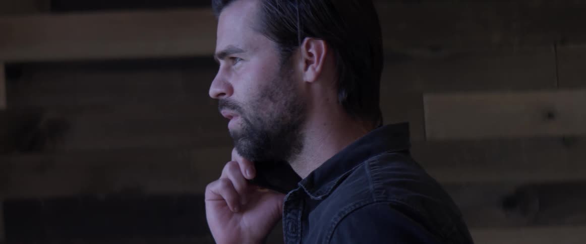 Man talking on a phone staring out a window