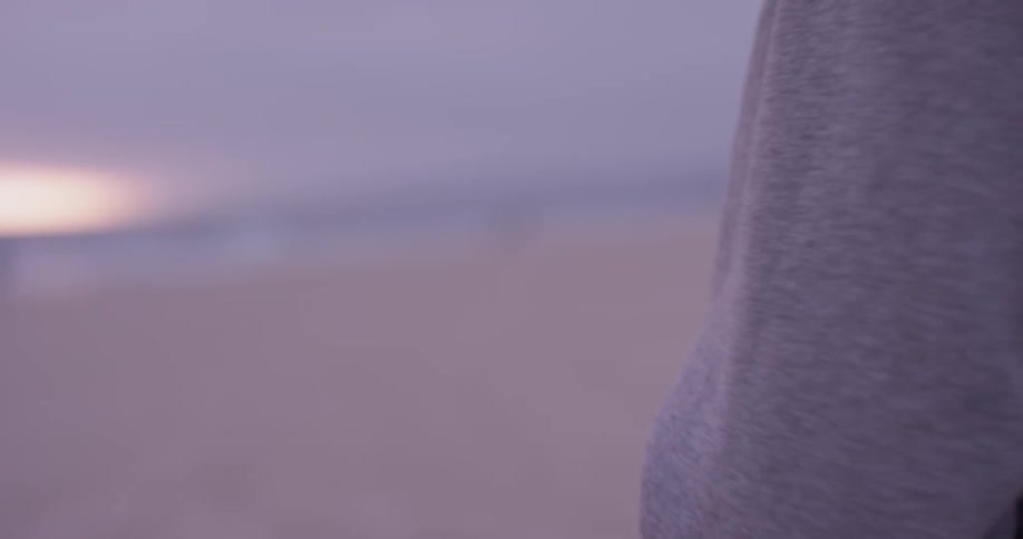 Woman holding a football on the beach