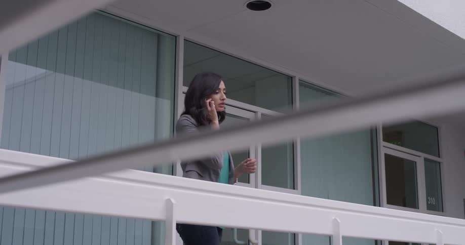 A woman talking on a cell phone on a balcony