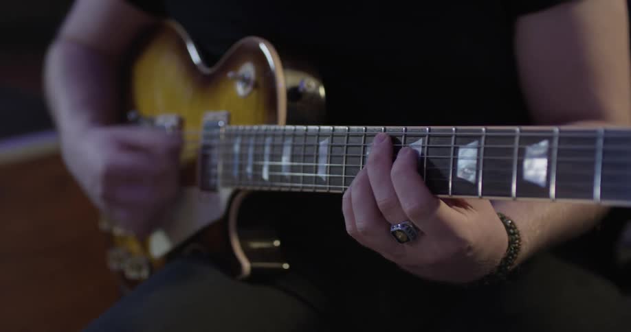Person plays a guitar in the evening